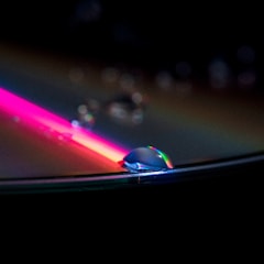 Close-up of a water droplet reflecting light with a mystical blue background