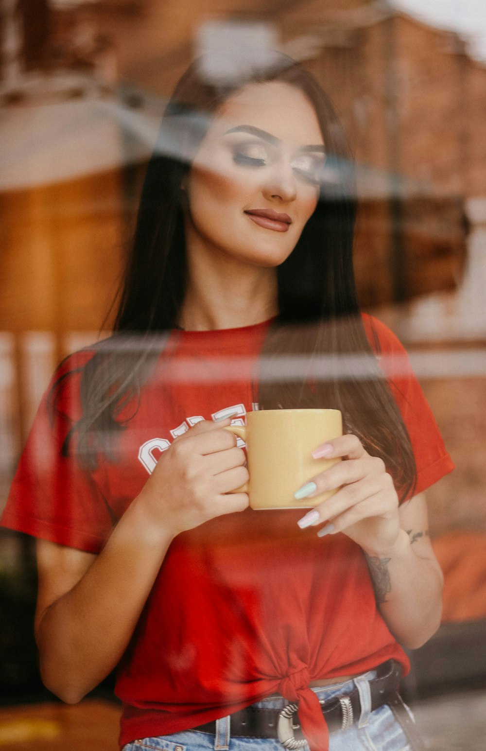 a woman in a red shirt holding a coffee cup
