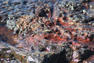 Close-up of a geopolimeric pot showing its gray-purple texture with volcanic greba and shimmering mica highlights.