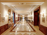 Luxurious hotel corridor in black and gold tones leading to premium rooms.
