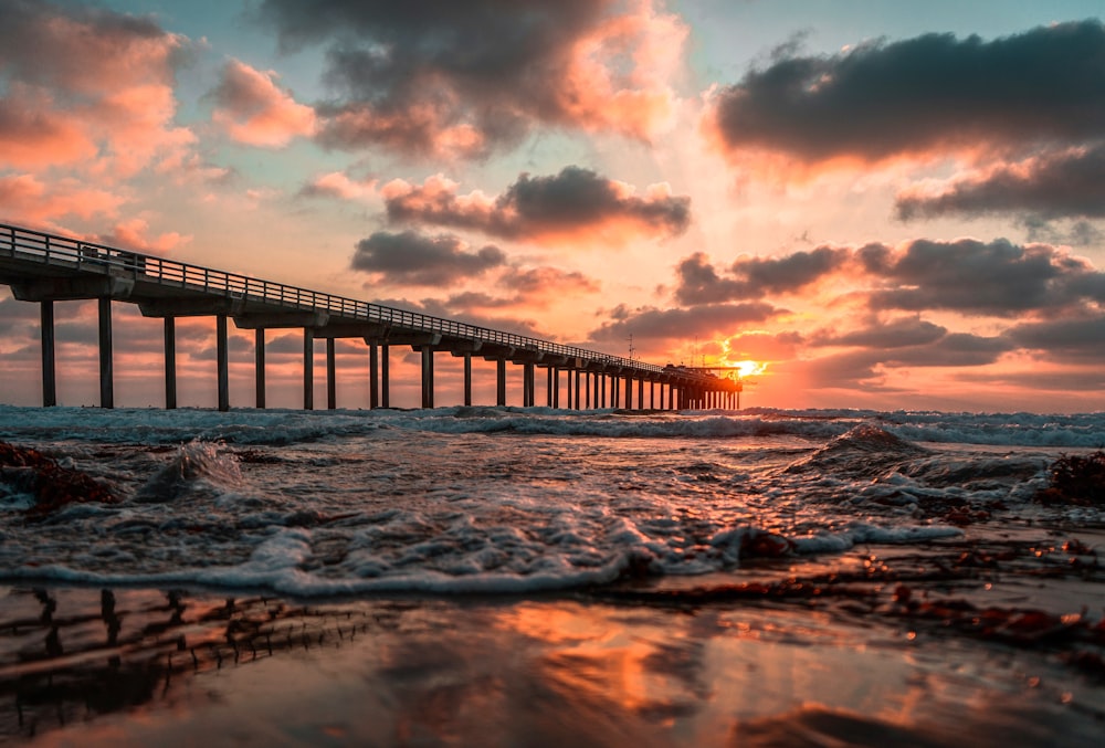 sea waves under gray and white clouds during sunset