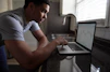 A focused man reviewing digital charts on a sleek laptop.