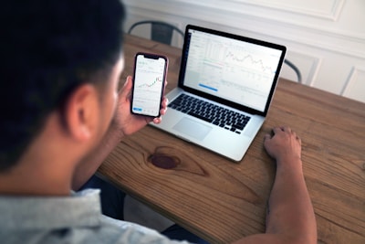 person holding iphone 6 near macbook pro