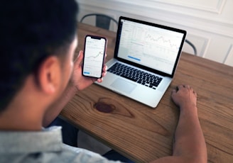 person holding iphone 6 near macbook pro