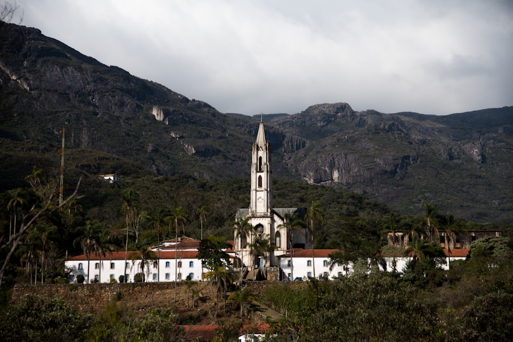 white and brown concrete building near mountain under white sky during daytime