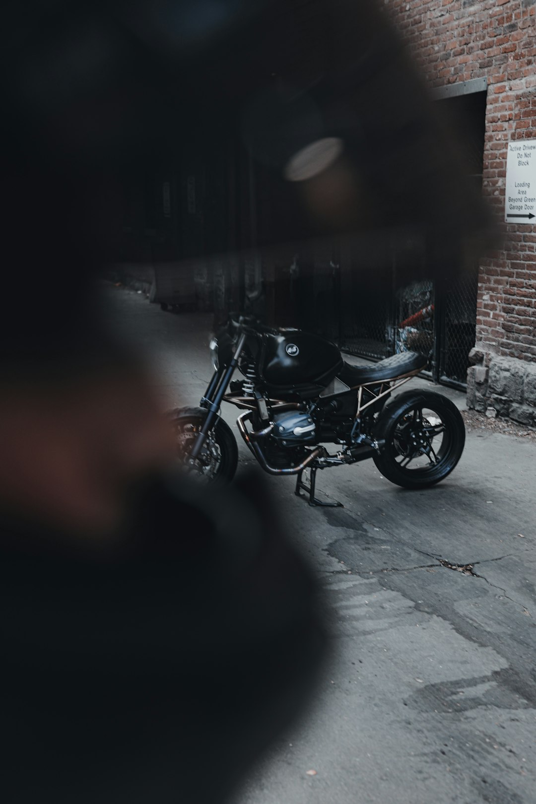 black motorcycle parked beside wall