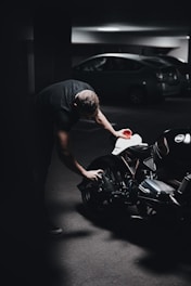 man in black t-shirt riding black sports bike