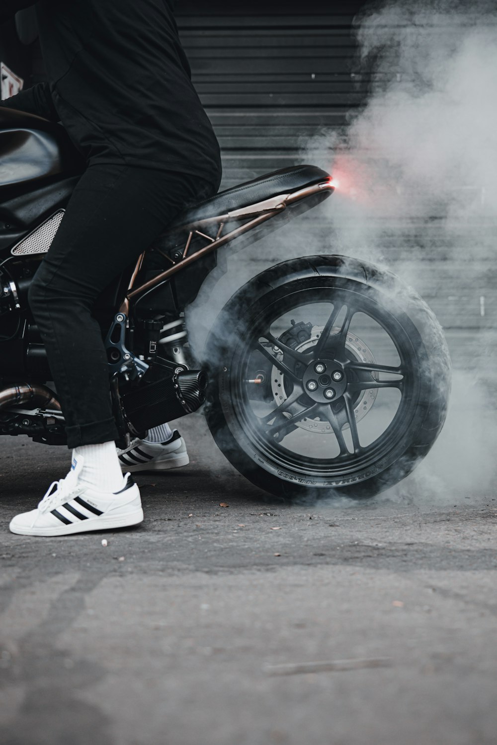 man in black jacket and white pants riding black motorcycle