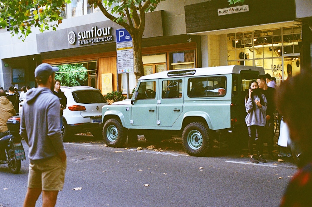 man in white shirt and black pants standing beside white and black jeep wrangler