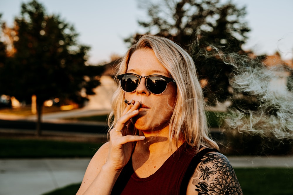 Mujer con camisa floral blanca y negra con gafas de sol negras