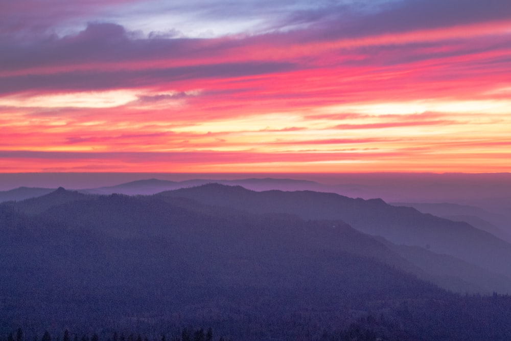 mountains under orange and blue sky during sunset