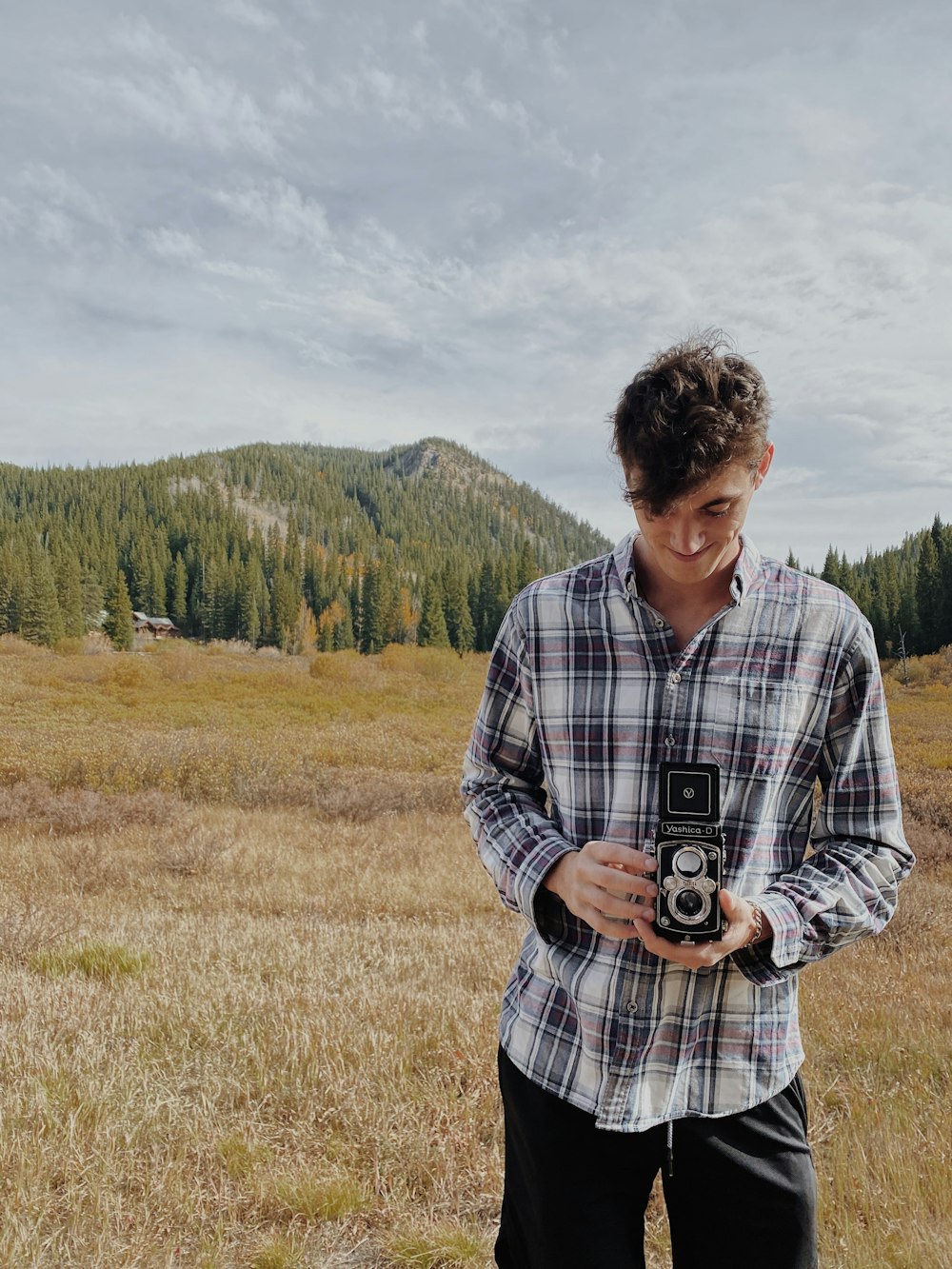 man in white and black plaid dress shirt standing on green grass field during daytime