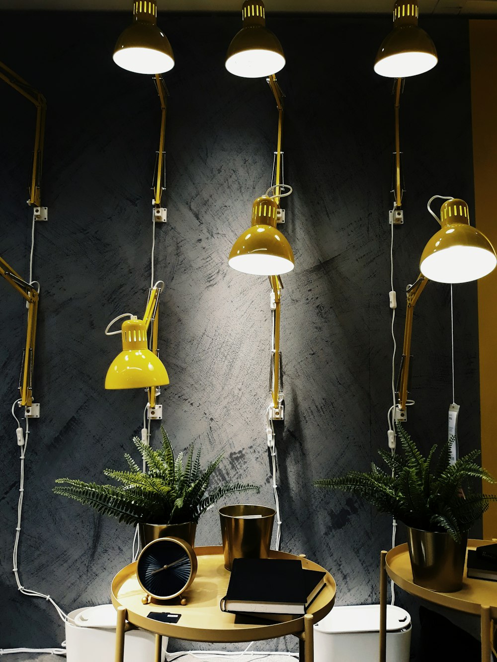 a room with three lamps and a table with a potted plant