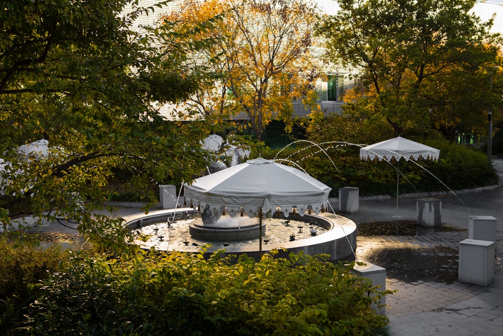 white and gray gazebo near trees and houses during daytime