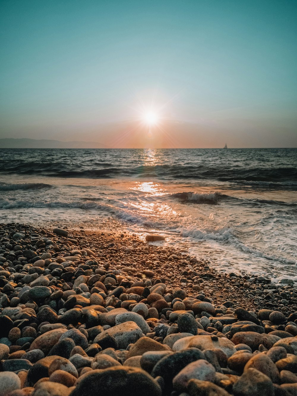 Rocas marrones en la orilla del mar durante la puesta de sol