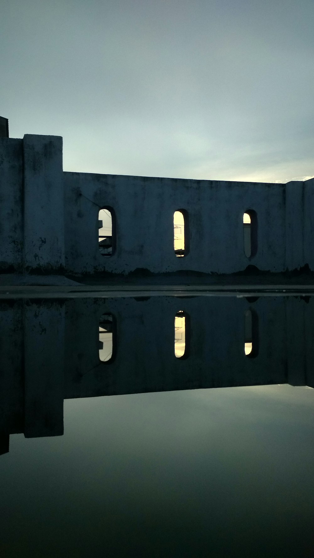 black concrete building under white clouds during daytime