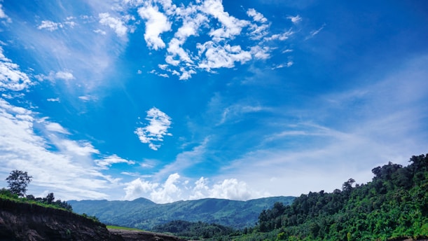 A vibrant landscape of lush green mountains under a clear blue sky in Colombia.