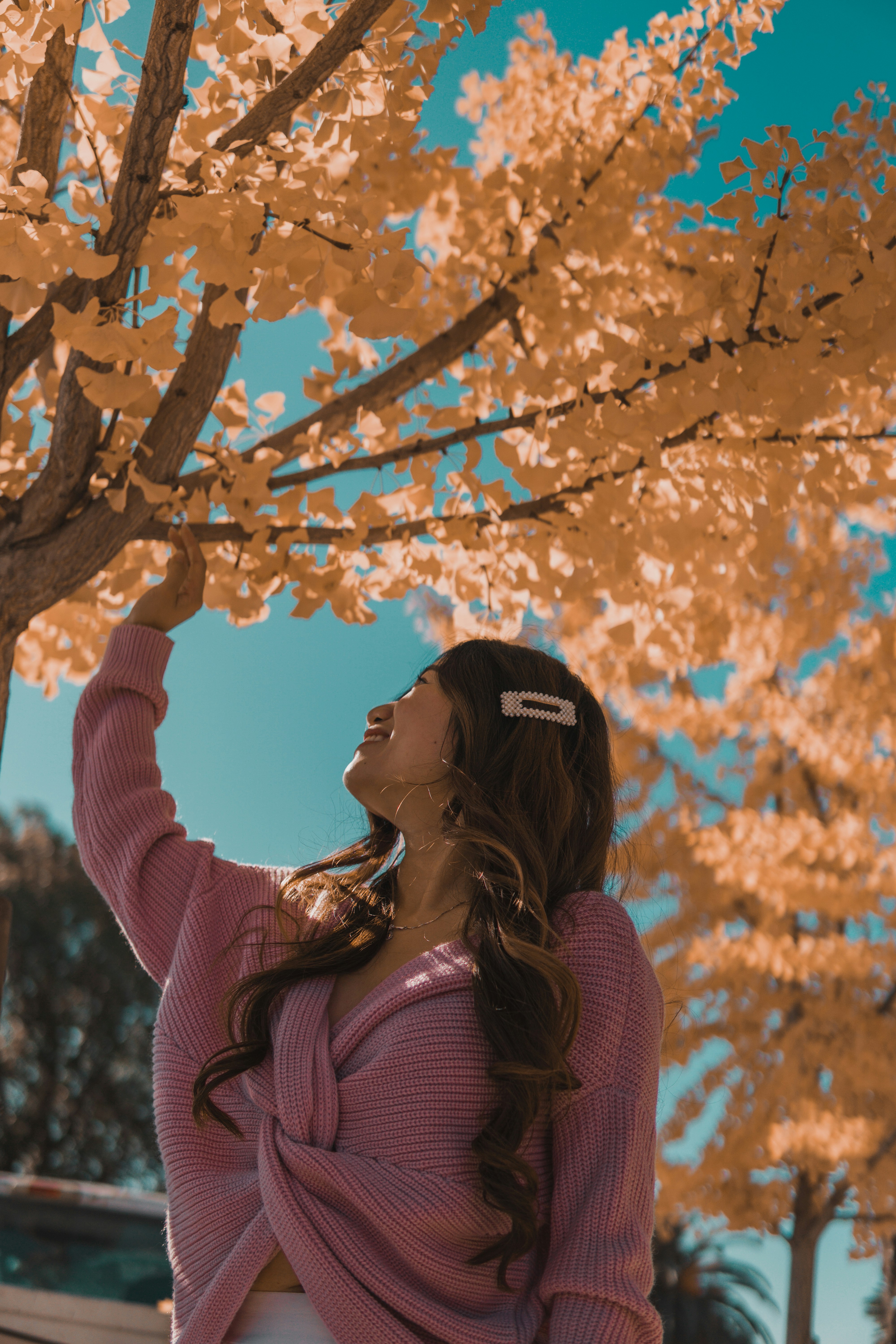 donna in maglione rosa che indossa cuffie nere