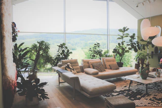 A cozy modern living room with large windows showcasing a beautiful garden view.
