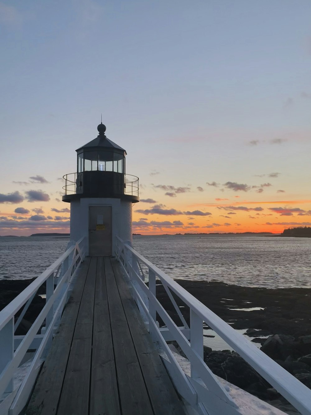 white wooden dock on sea during sunset