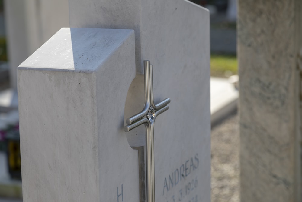 silver cross on white concrete wall