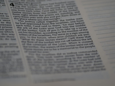 A close-up of text from a book with a biblical or religious theme. The text appears formatted in columns and includes chapter and verse numbers. The page is in focus on the left and gradually blurs toward the right edge.