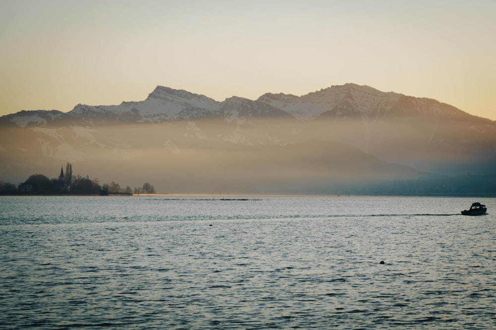 body of water near mountain during daytime