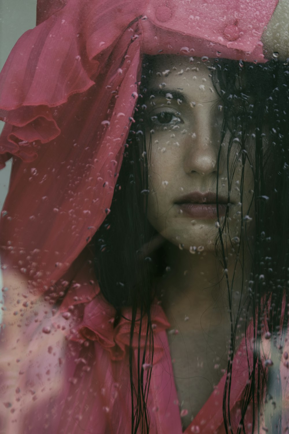 woman in red dress covering her face with red textile