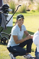 a woman kneeling down next to a baby carriage