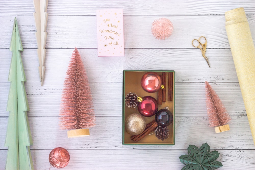 red and gold round ornament on white wooden table