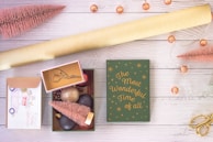 A festive flat lay featuring an assortment of Christmas card decorations including miniature wreaths and bells.