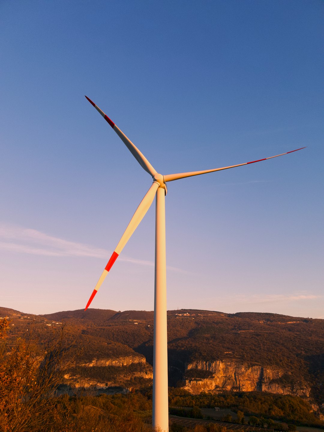 white wind turbine on brown field under blue sky during daytime