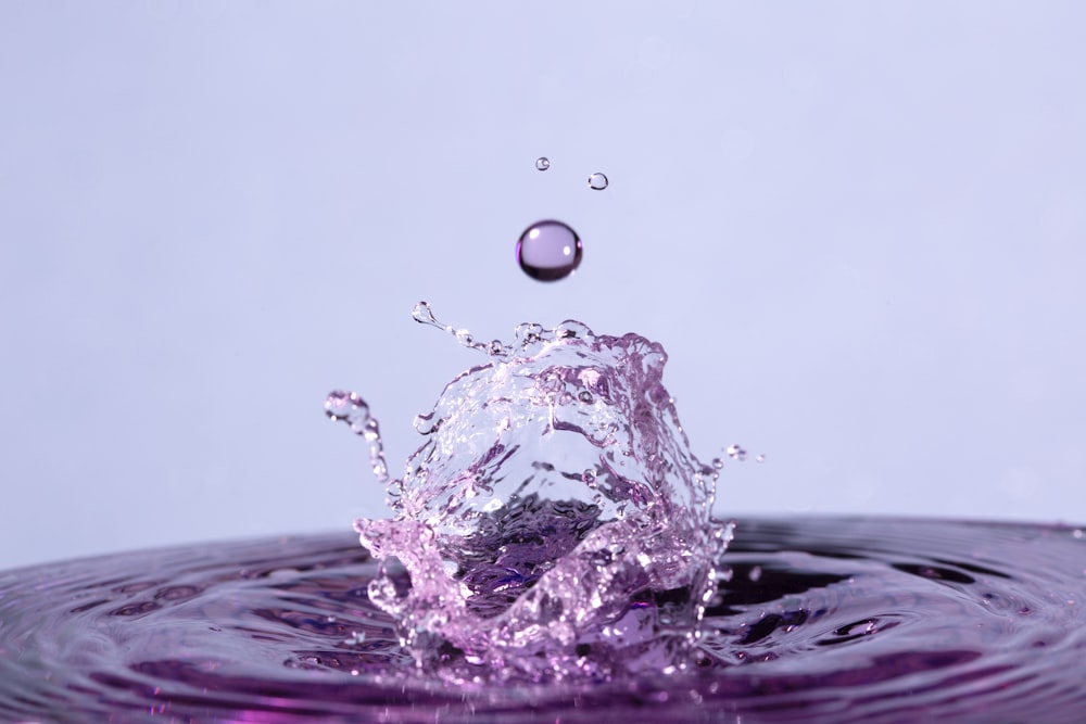 Wassertropfen auf violettem Wasser