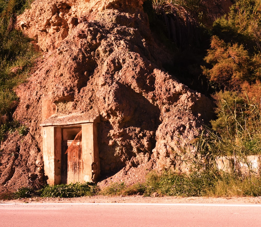 brown rock formation near green grass during daytime