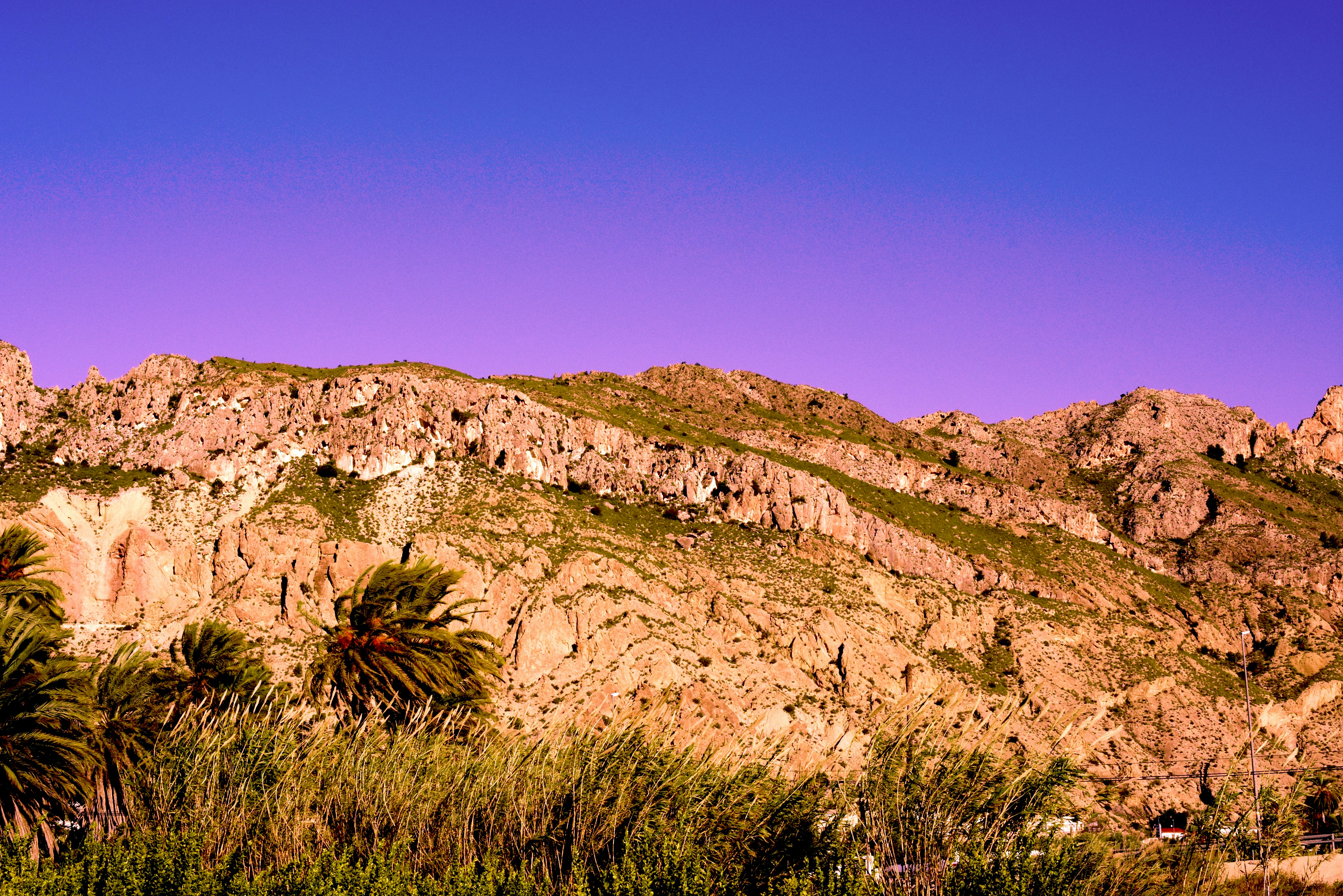 green grass on brown mountain under blue sky during daytime, Montaña de Murcia.