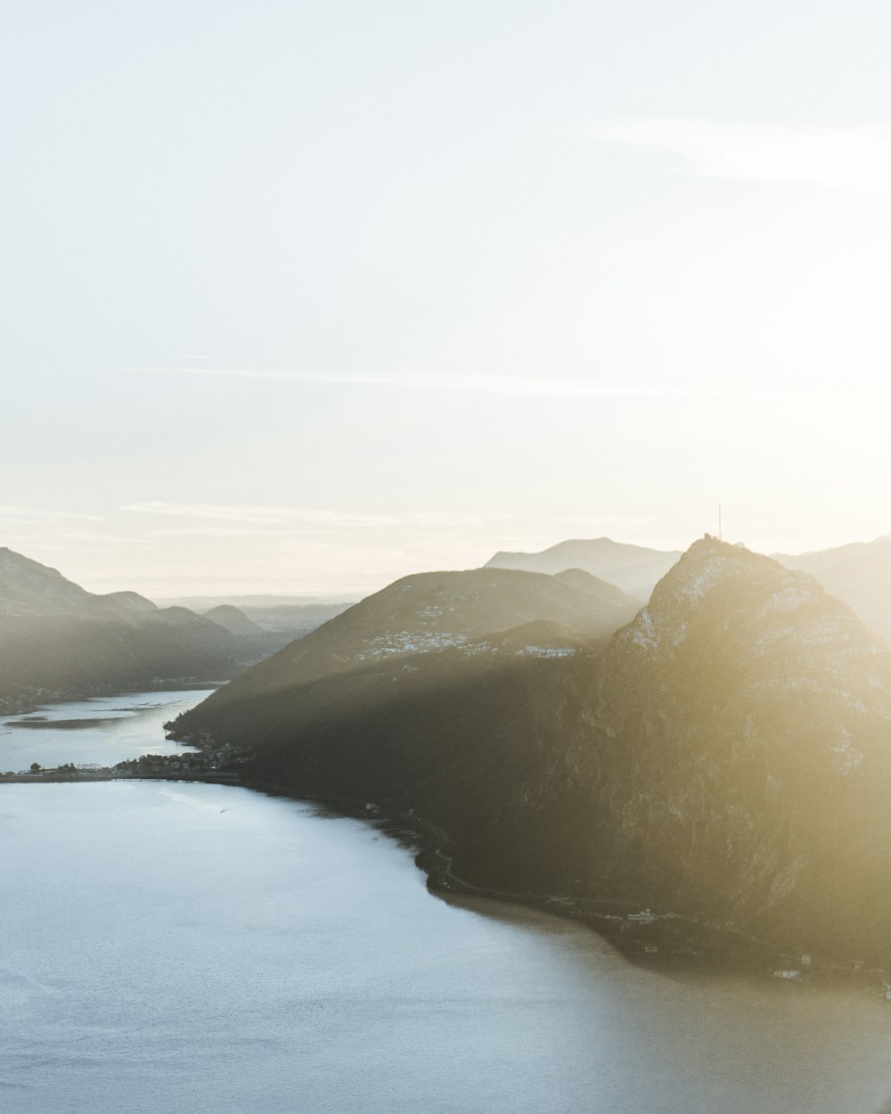 brown mountain near body of water during daytime