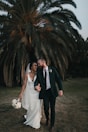 a newly married couple walking through a field
