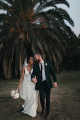 a newly married couple walking through a field