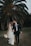 a newly married couple walking through a field
