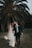 a newly married couple walking through a field