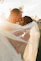 A joyful couple sharing a tender moment during their wedding celebration in a sunlit garden.