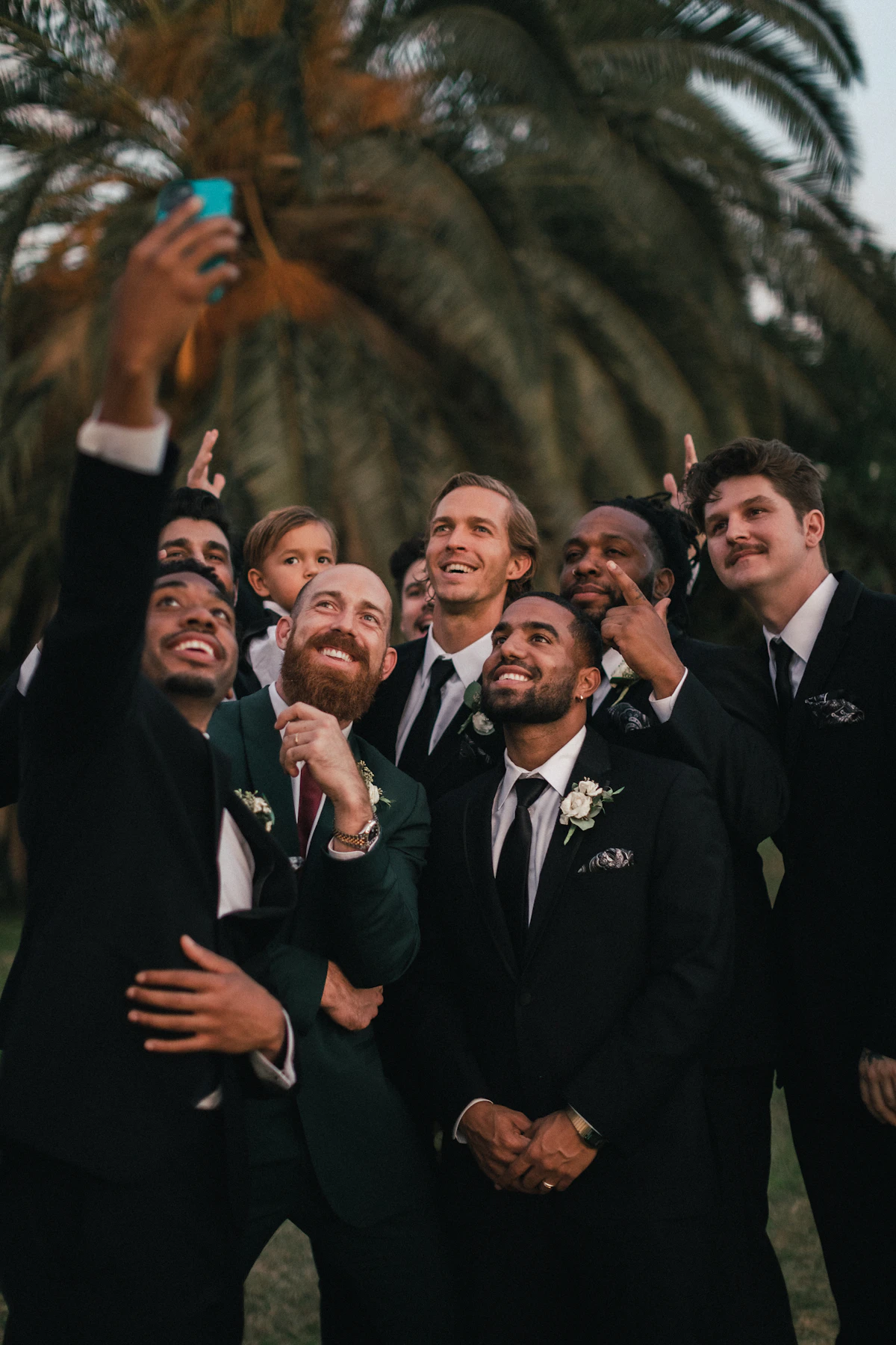 Groomsmen in tuxedos gathered in a softly lit lounge.