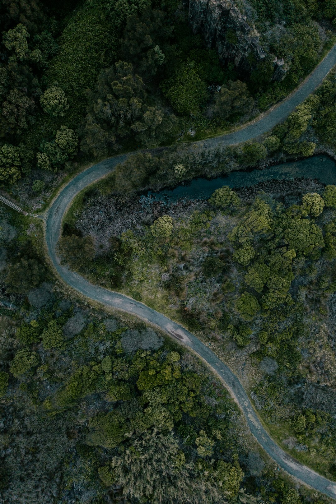 aerial view of road in the middle of green grass field