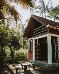 brown wooden house near green trees during daytime