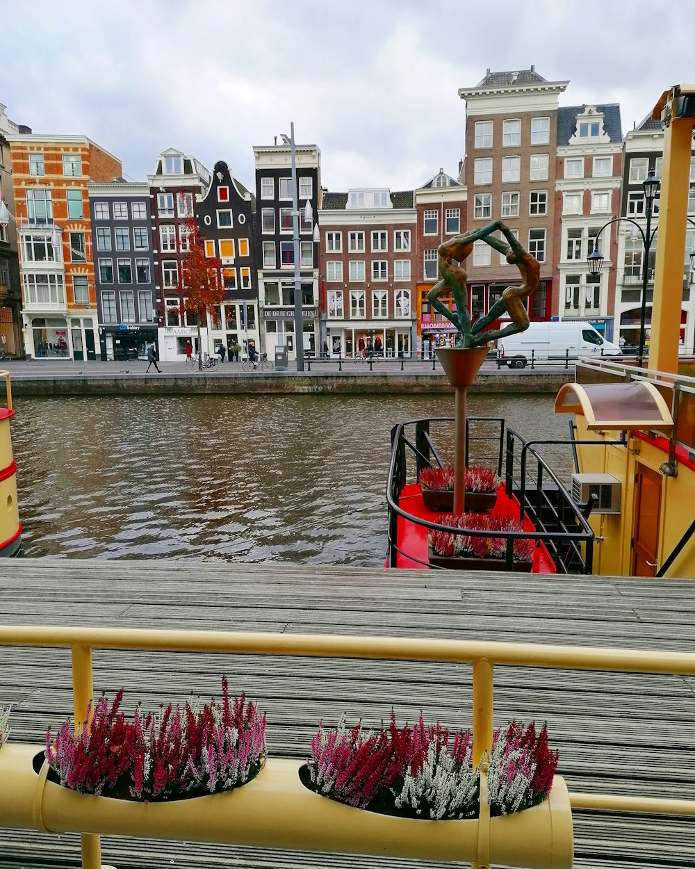 barco vermelho e branco na água perto de edifícios durante o dia