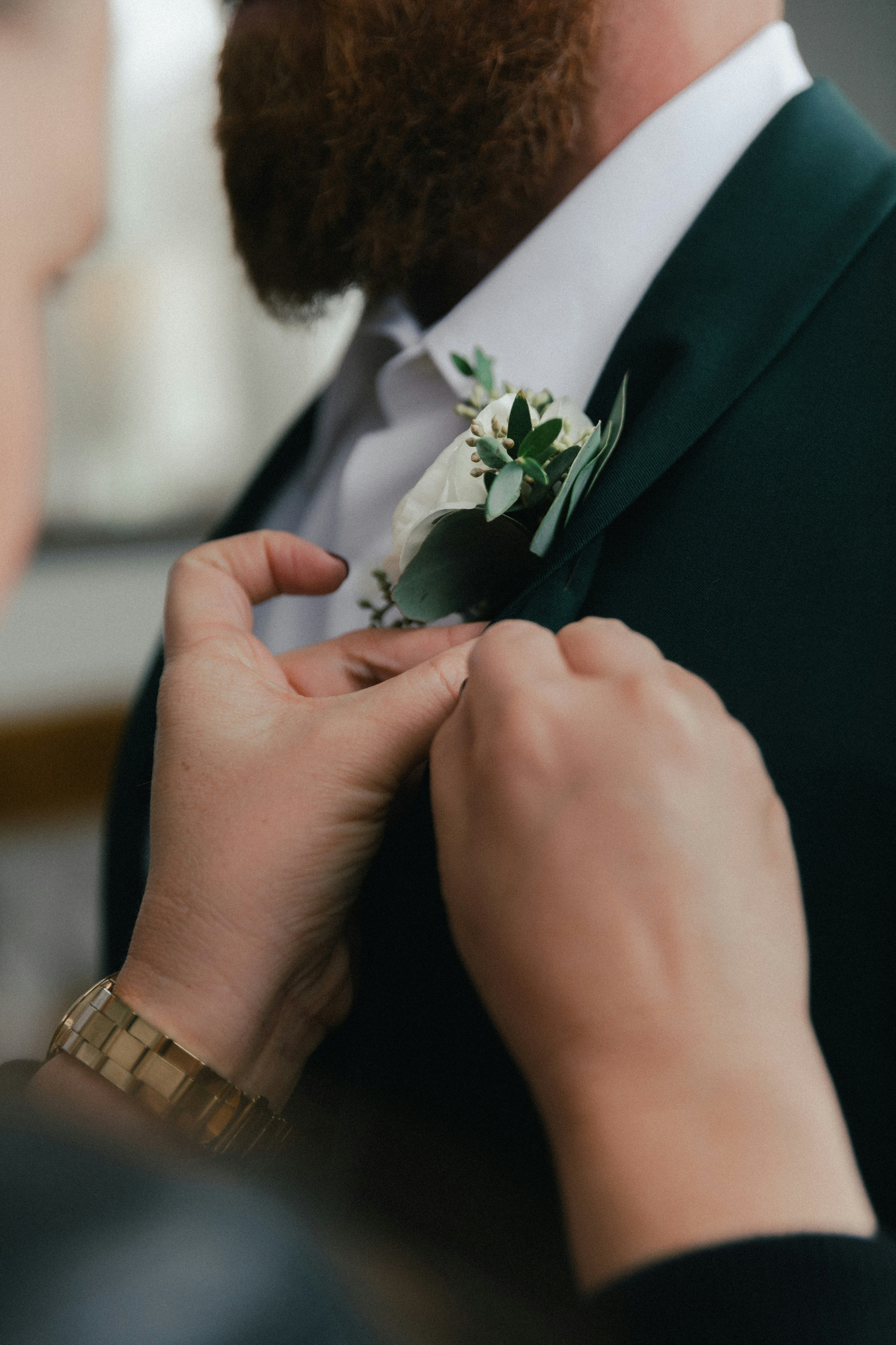 man-in-black-suit-holding-white-flower