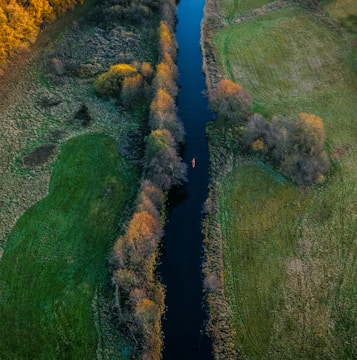 A kayaker navigating crisp, clear river rapids surrounded by autumn-colored foliage
