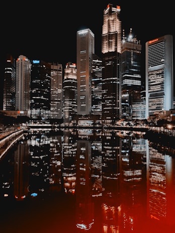 Night view of a city skyline with illuminated buildings reflecting modern progress.