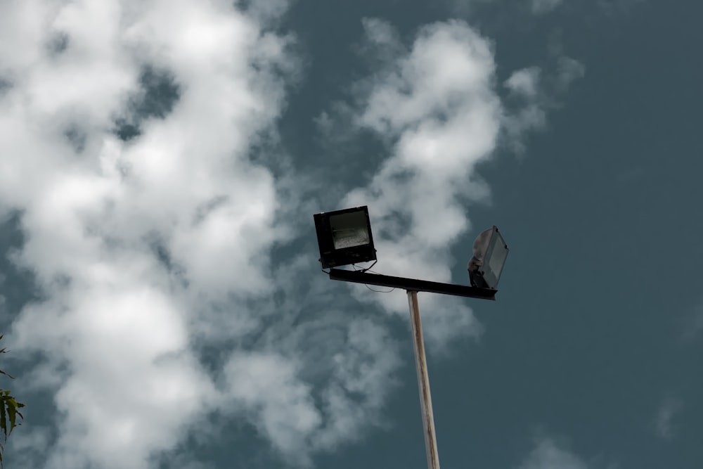 black and white street light under white clouds and blue sky during daytime