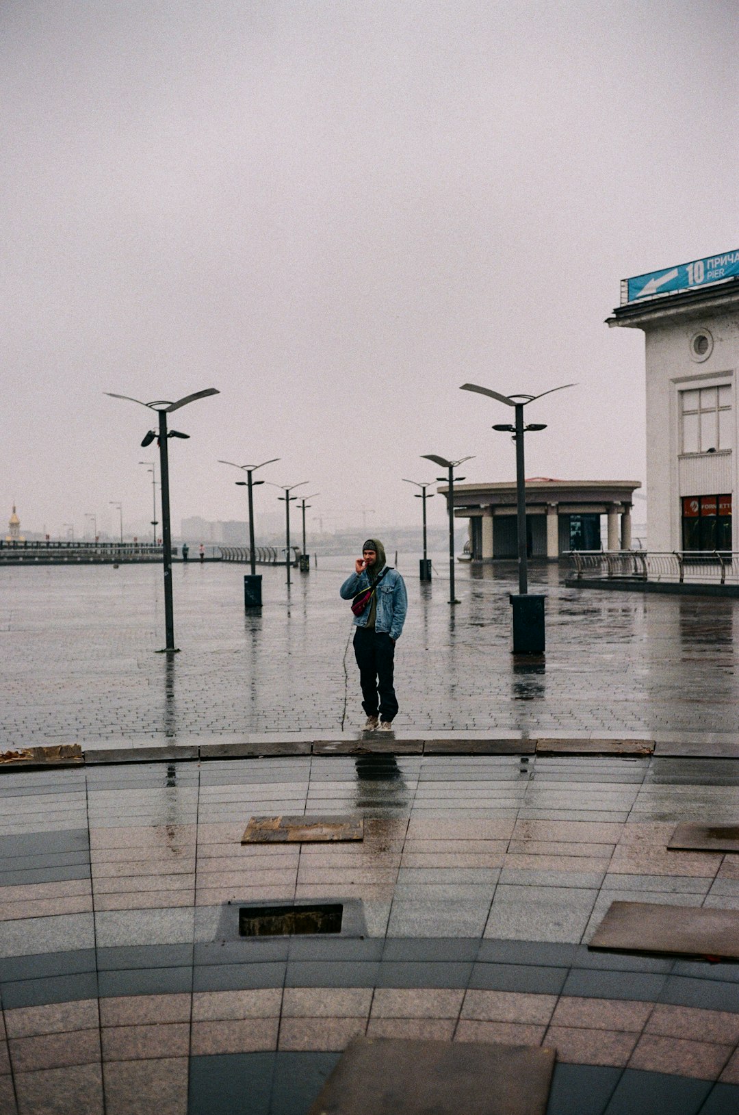 woman in blue denim jacket standing on dock during daytime